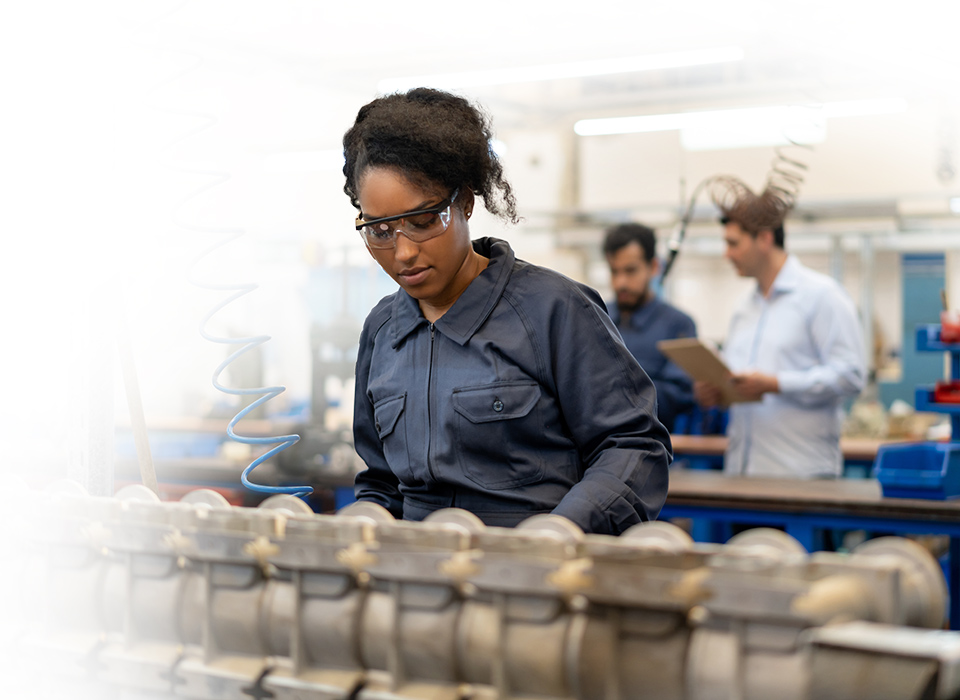 girl working on an assembly line in a blue jumper with glasses on