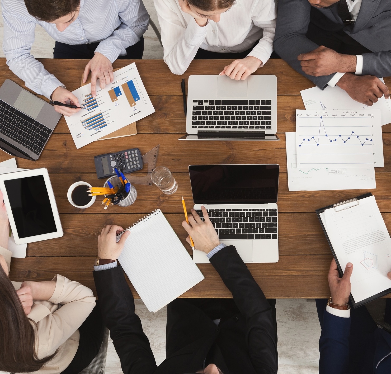 iStock-996183898 Diverse business team at meeting, discussing marketing strategy and working on gadgets, top view