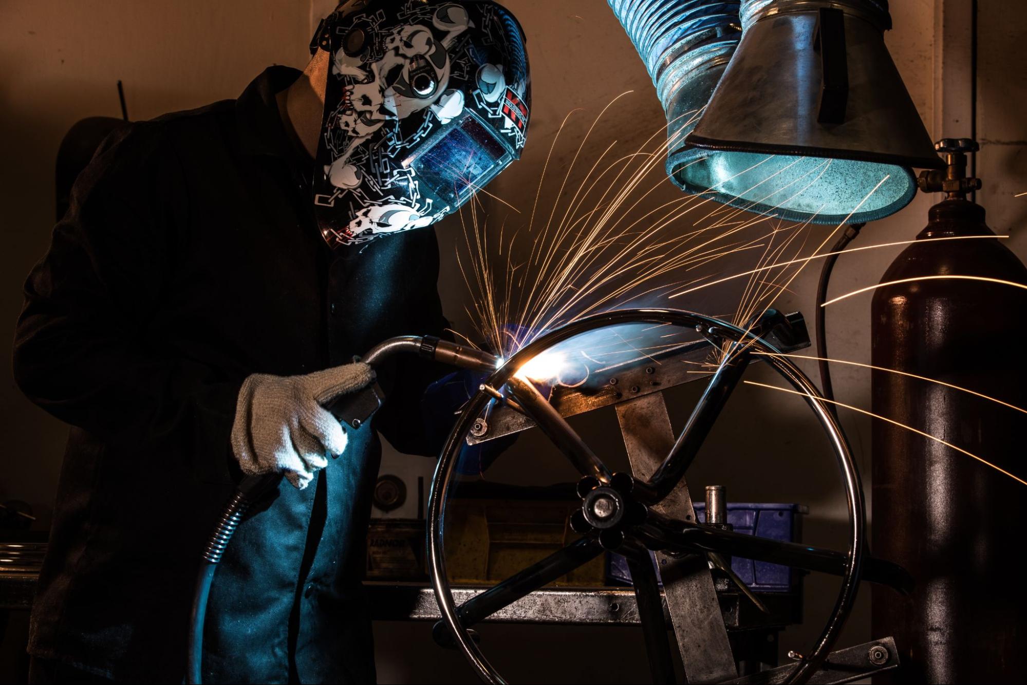person welding the bottom of a chair