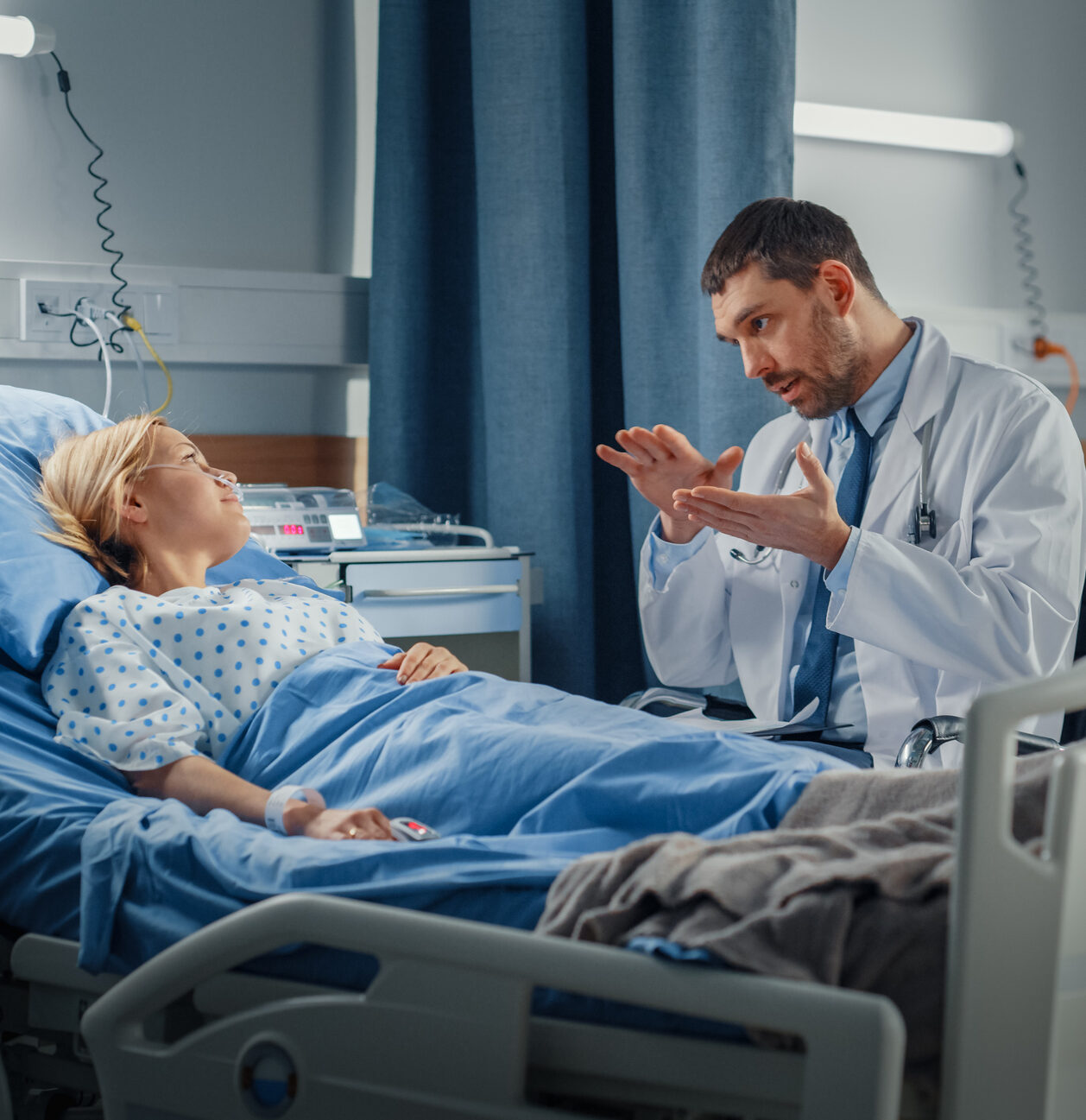 Hospital Ward: Friendly Doctor Talks to Smiling Young Woman Resting in Bed, Fully Recovering after Sickness. Physician Uses Tablet Computer, Does Checkup, Gives Treatment Advice, Health Recommendation