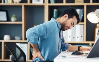 man wincing in pain at his uncomfortable chair